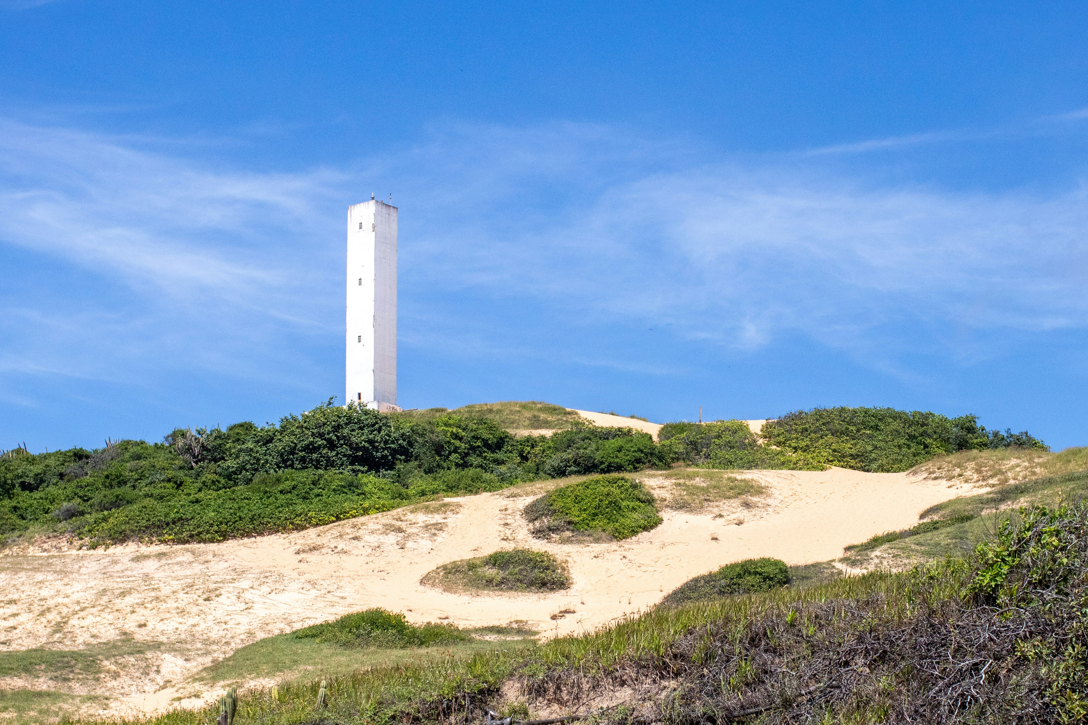 white concrete tower on brown field under blue sky during daytime